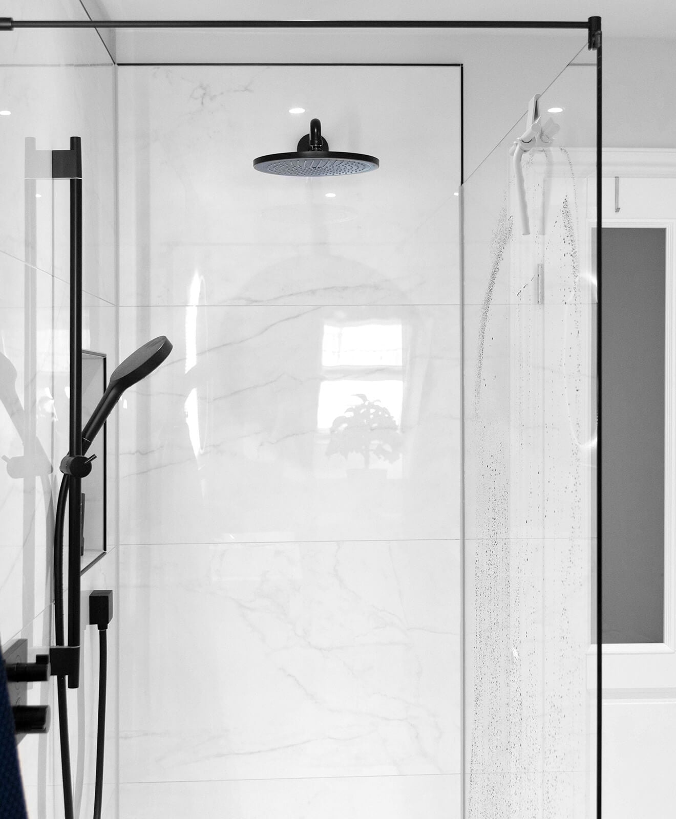 Abzieher aus Silikon in Weiß für Bad und mehr von KAWENTSMANN aufgehängt an der Scheibe der Duschkabine