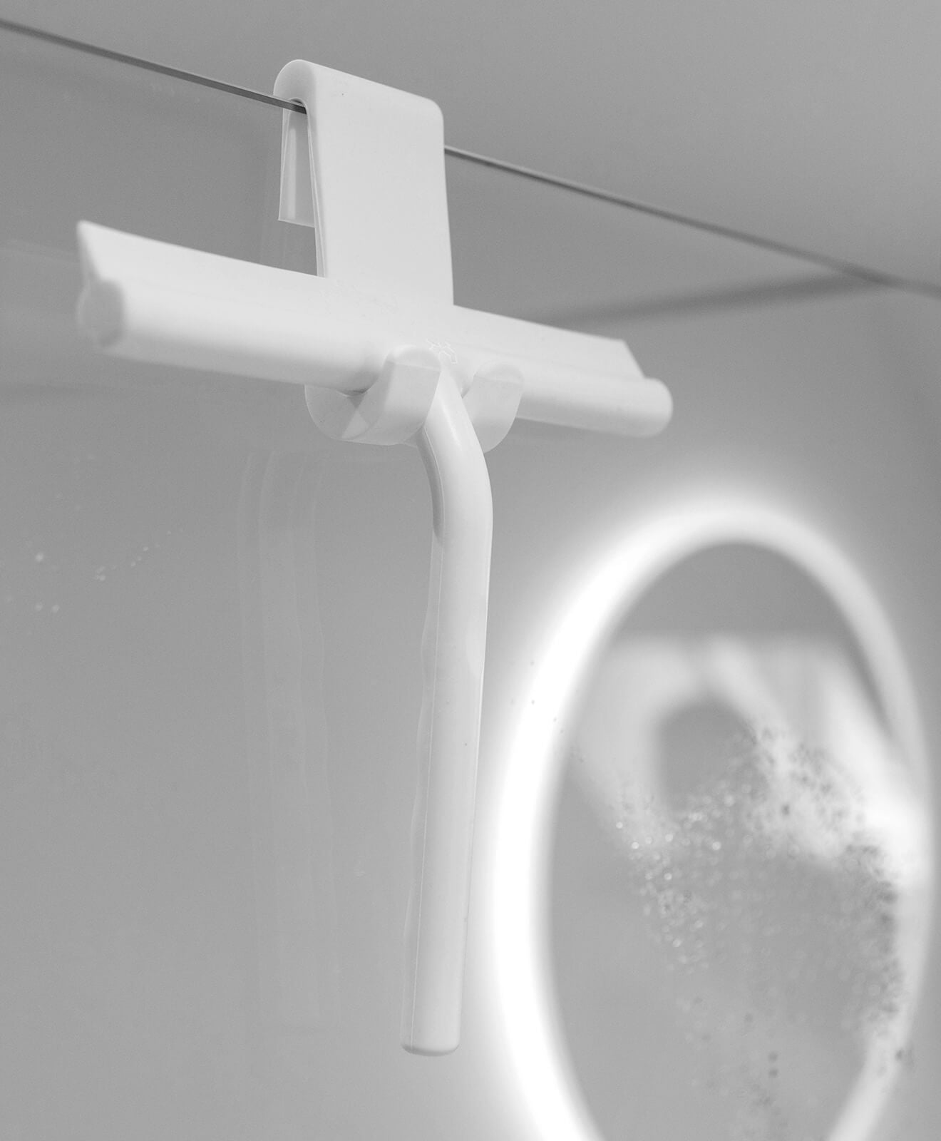Abzieher aus Silikon in Weiß für Bad und mehr von KAWENTSMANN aufgehängt an der Scheibe der Duschkabine