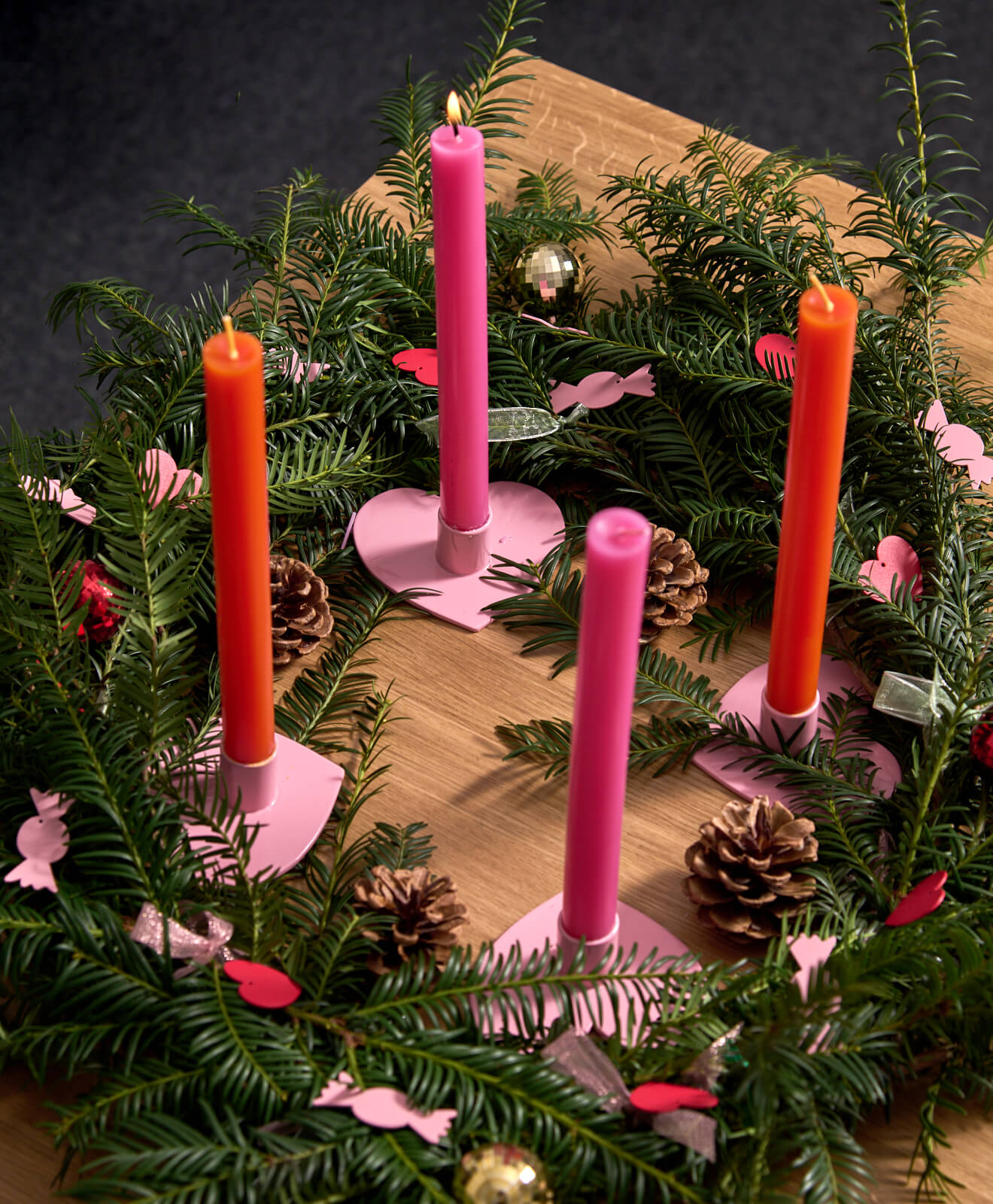 Kerzenständer in Herzform als Adventskranz arrangiert
