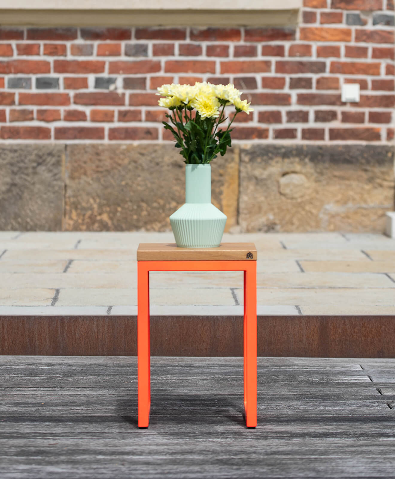 Vase 3D Druck von Kawentsmann in Kooperation mit Recozy LIV in Pistachio Green aufgestellt auf einem Hocker mit gelben Blumen drin