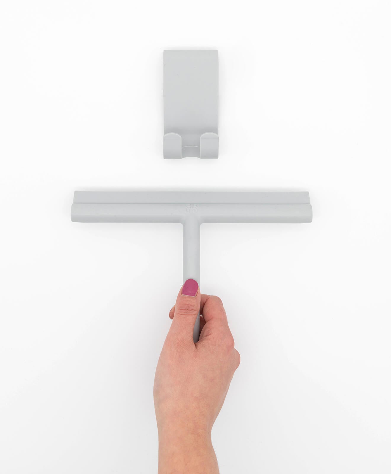 Abzieher aus Silikon für Bad und mehr von KAWENTSMANN in Grau in der Hand gehalten