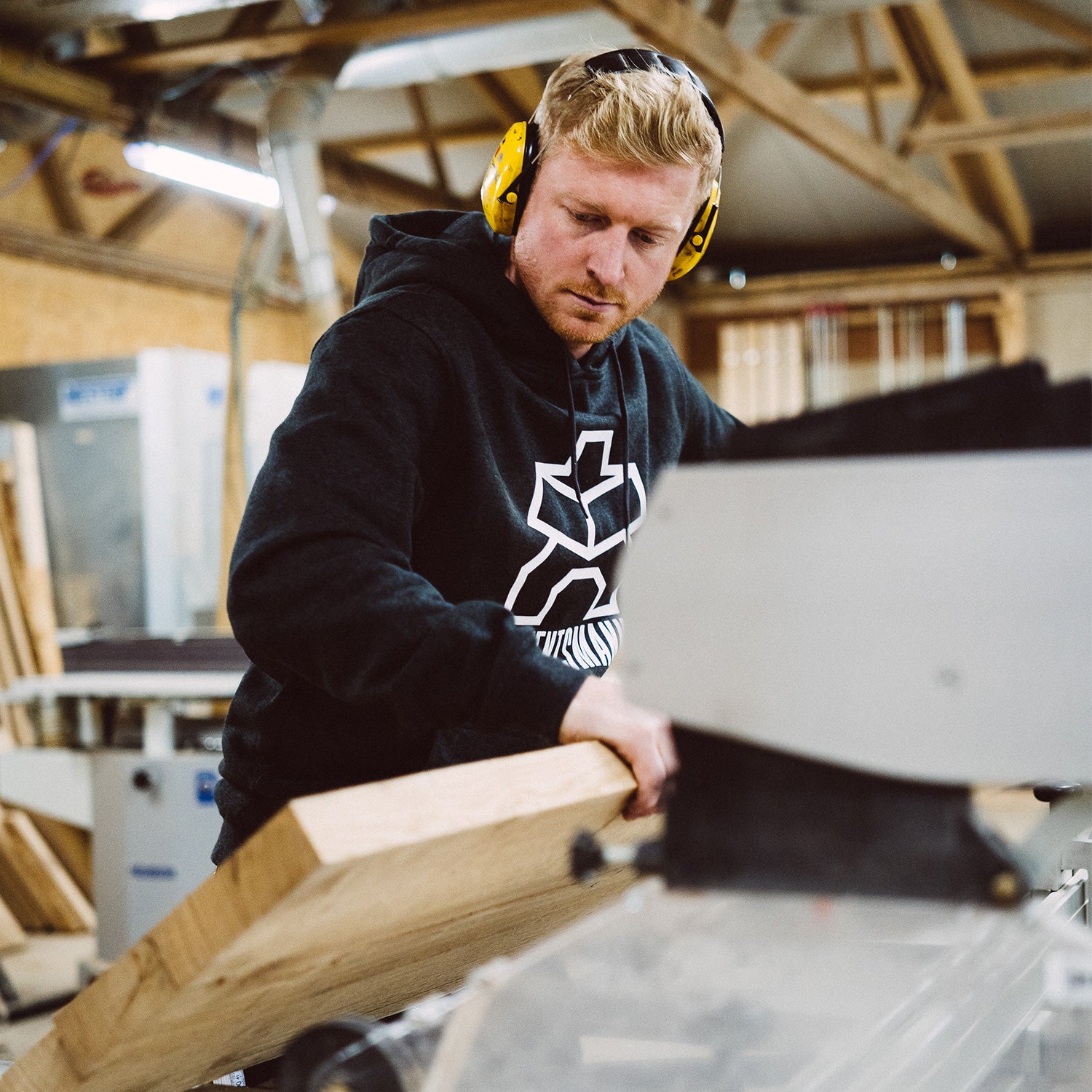 Max Bayer-Eynck Gründer und Geschäftsinhaber von Kawentsmann in der Werkstatt mit einer Holzplatte in den Händen zur Veranschaulichung der Karrieremöglichkeiten bei Kawentsmann