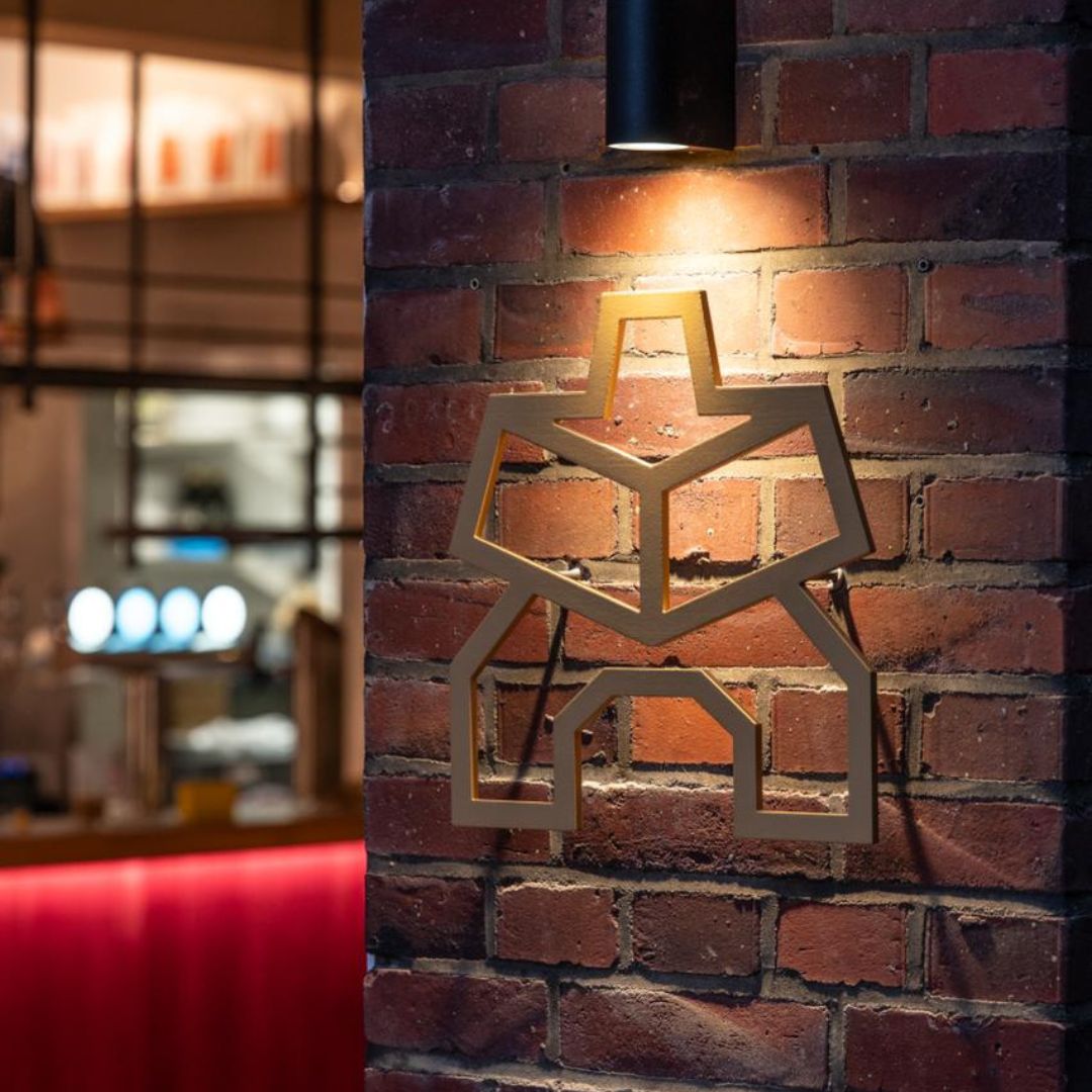 Kawentsmann Logo aus Metall, angebracht an der Fassade unseres Cafés