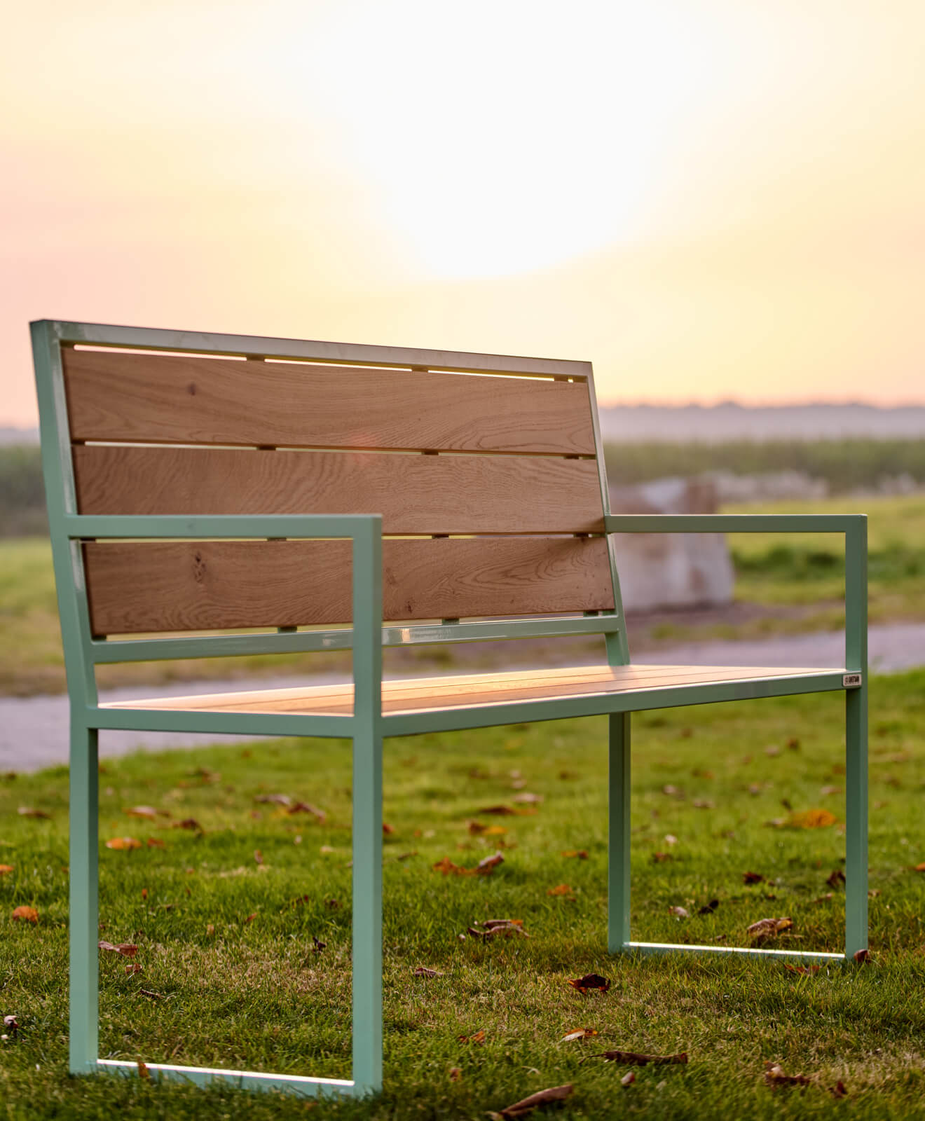Sitzbank Outdoor mit Rücken- und Armlehne beim Sonnenaufgang