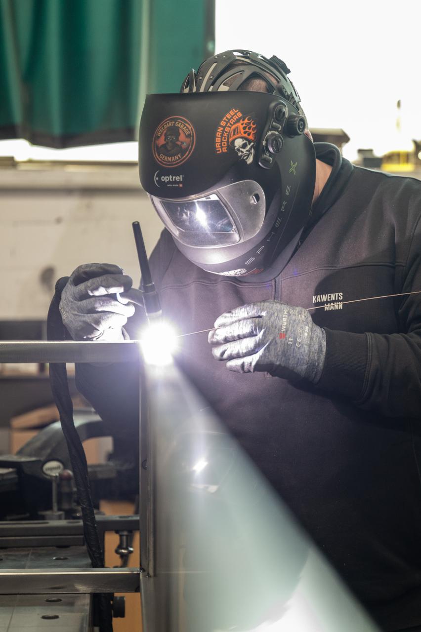 Schweißer arbeitet an Stahlgestell