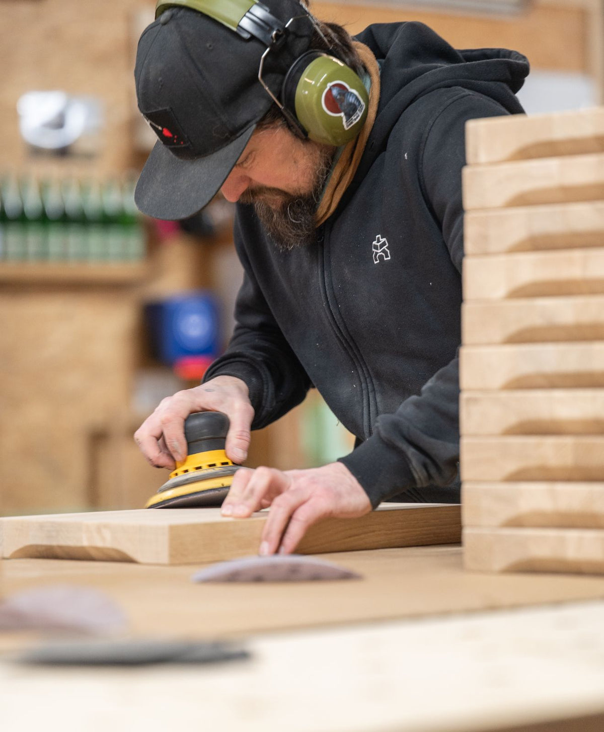 Teammitglied Till schleift ein Schneidebrett BEMME in unserer Werkstatt zur Darstellung der Handarbeit bei unseren Schneidebrettern