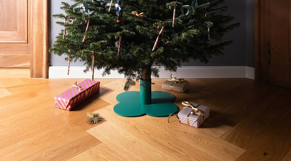 Weihnachtsbaumständer KLEE in Opalgrün im Wohnzimmer mit Geschenken